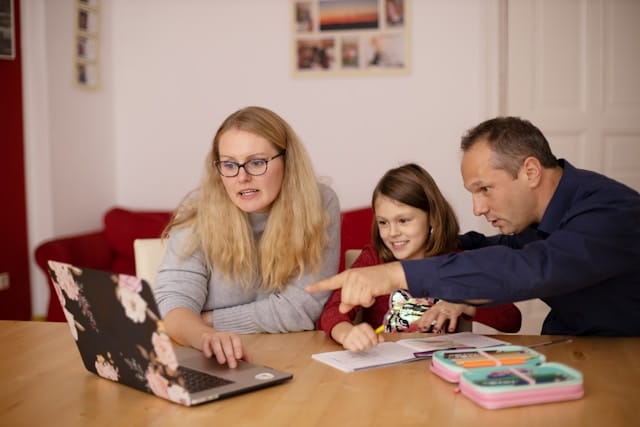 Child doing homework with parents